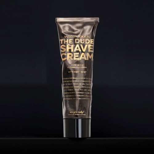 A black tube with gold and white text, labeled as men's shave cream, stands vertically against a black background.