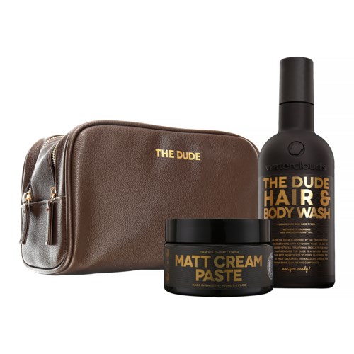 A brown toiletry bag with gold text, alongside a black bottle and a jar of matte cream paste.