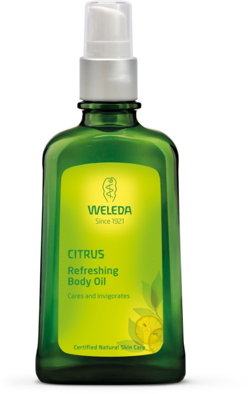 Eine grüne Flasche Weleda Citrus Refreshing Body Oil mit Pumpspender, beschriftet für Hautpflege und belebenden Duft.