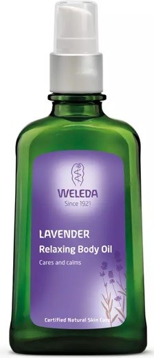 Eine grüne Flasche mit Lavendel-Entspannungs-Körperöl, lila Etikett, weißer Pumpe und Weleda-Marke.