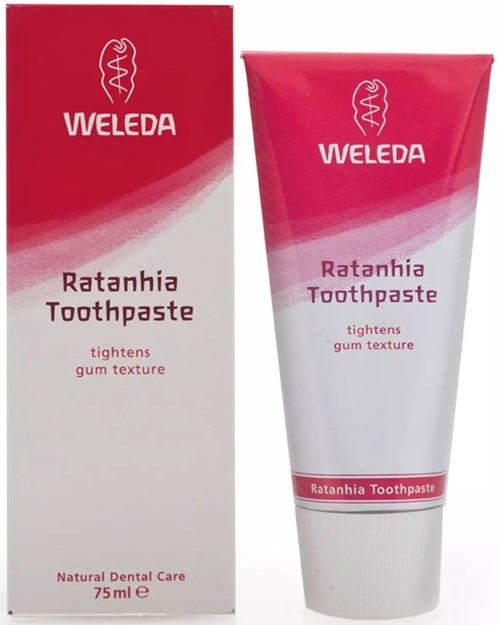 A tube of Weleda Ratanhia Toothpaste and its box, both in red and white colors, highlighting dental care.