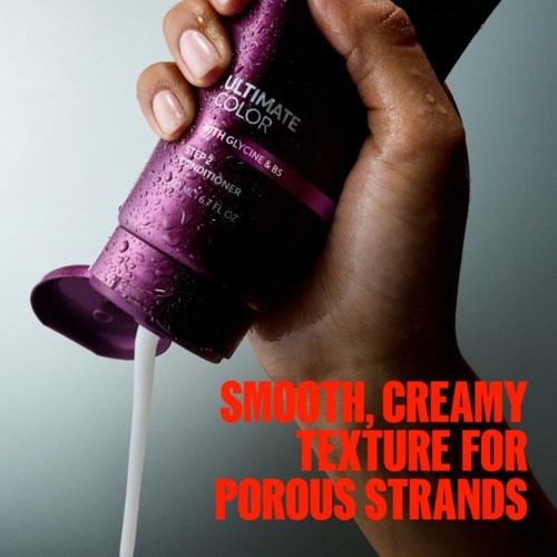 Een hand houdt een paarse fles conditioner met tekst die een gladde, crèmige textuur voor poreuze plukken benadrukt.
