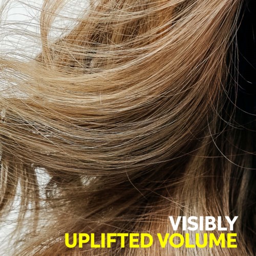 Close-up of hair showing lifted volume signs, highlighting shiny, wavy blond locks with a glossy look.