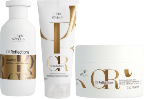 Kolme hiustenhoitotuotetta nimeltä Oil Reflections: shampoo, hoitoaine ja naamio valkoisessa ja kullallisessa pakkauksessa.