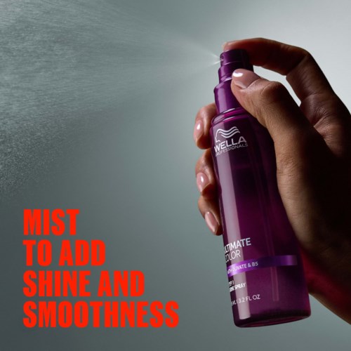 Een hand houdt een paarse sprayfles, spuit mist, met rode tekst voor glans en gladheid.