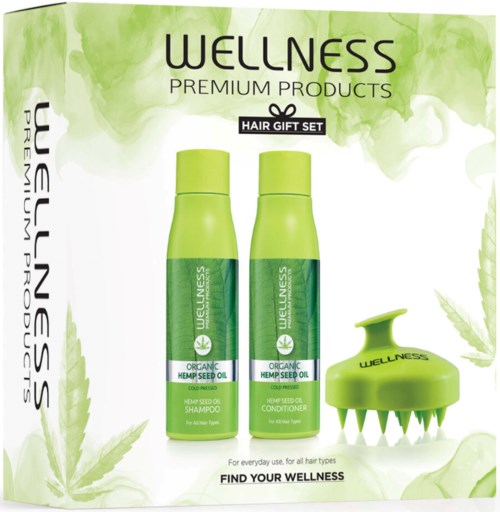 Two green bottles and a hairbrush with spikes, labeled wellness, promote organic hemp seed oil hair care.