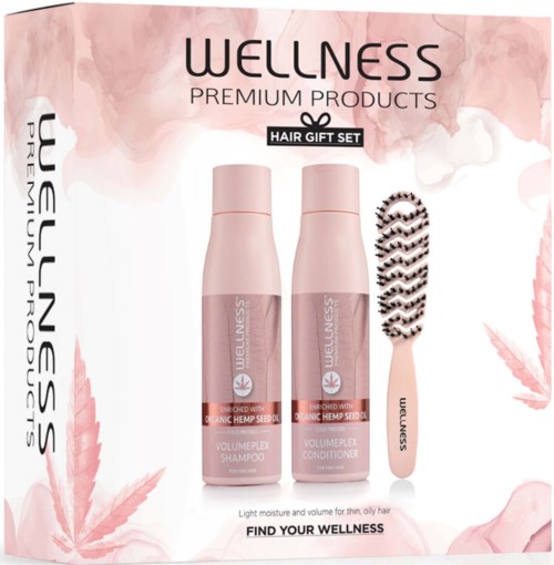 A wellness set with shampoo, conditioner, and a hairbrush, all in pink packaging, celebrating natural hair care.