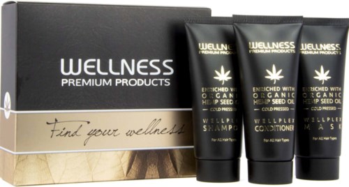 Drie zwarte flessen en een zwarte doos met Wellness Premium Products, met een goud- en wit ontwerp.