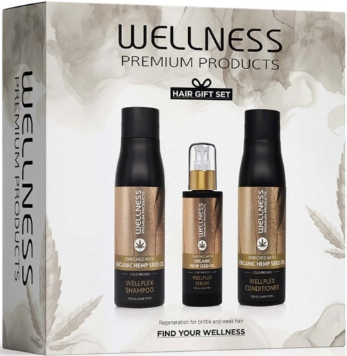 Een set van drie wellness haarproducten: shampoo, serum en conditioner in zwarte flessen.