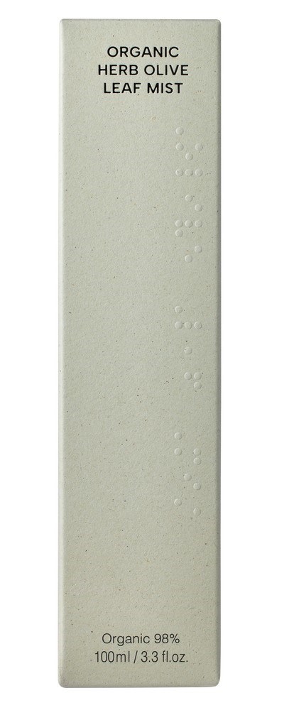 Ein langer weißer Karton mit schwarzem Text 'Organic Herb Olive Leaf Mist'. Er hat ein schlichtes, sauberes Design mit kleinen strukturierten Punkten.