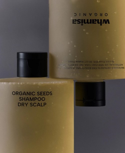 Zwei Flaschen Shampoo mit dem Aufdruck 'Organic Seeds Shampoo Dry Scalp', eine liegt und die andere steht.
