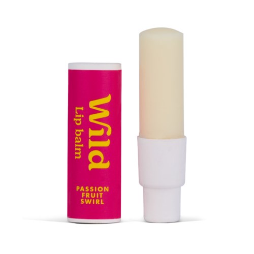 Een roze lippenbalsem tube met 'Wild', met een crèmekleurige lippenbalsem en een witte dop.