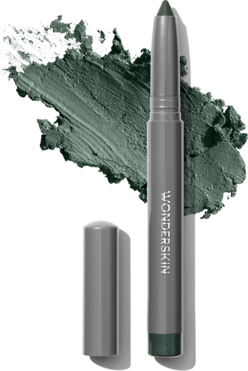Ein grüner Lidschattenstift mit Deckel, gezeigt mit verschwommenem grünen Lidschatten im Hintergrund.