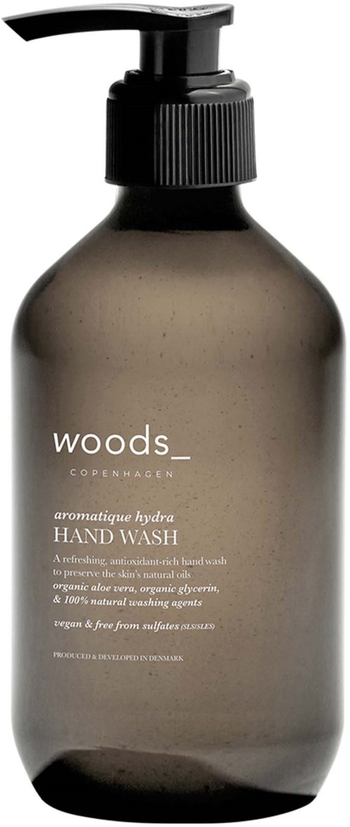A dark gray hand wash bottle with a pump, label says 'Woods Copenhagen aromatic hydran hand wash' and details.