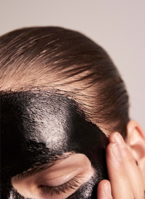 Eine Person mit Haarfarbe oder Behandlung auf der Kopfhaut, die den Haaransatz und die Stirn bedeckt.