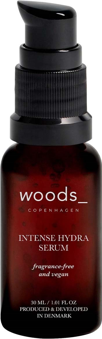 Eine kleine braune Flasche mit schwarzem Pumpkopf, Beschriftung 'Woods Copenhagen Intense Hydra Serum', duftfrei und vegan.