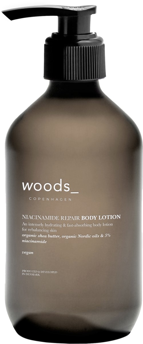 Eine dunkle Flasche mit Pumpverschluss enthält Woods-Copenhagen Körperlotion, gekennzeichnet als Niacinamid-Reparatur, zur Hautfeuchtung.