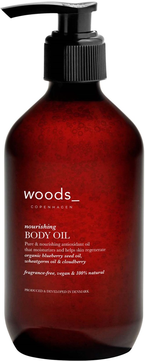 Eine rotbraune Flasche mit Pumpe, beschriftet "Woods Copenhagen nourishing body oil" zur Hautpflege.