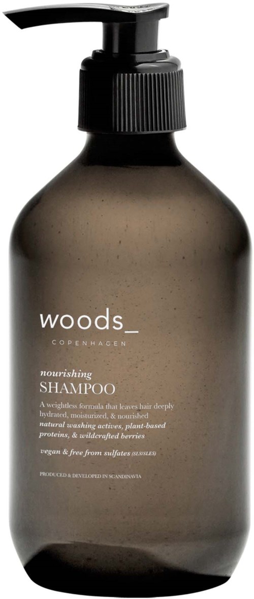 En mørkegrå sjampo flaske med svart pumpe og minimalistisk hvit tekst, inkludert merket 'woods' og produktdetaljer.