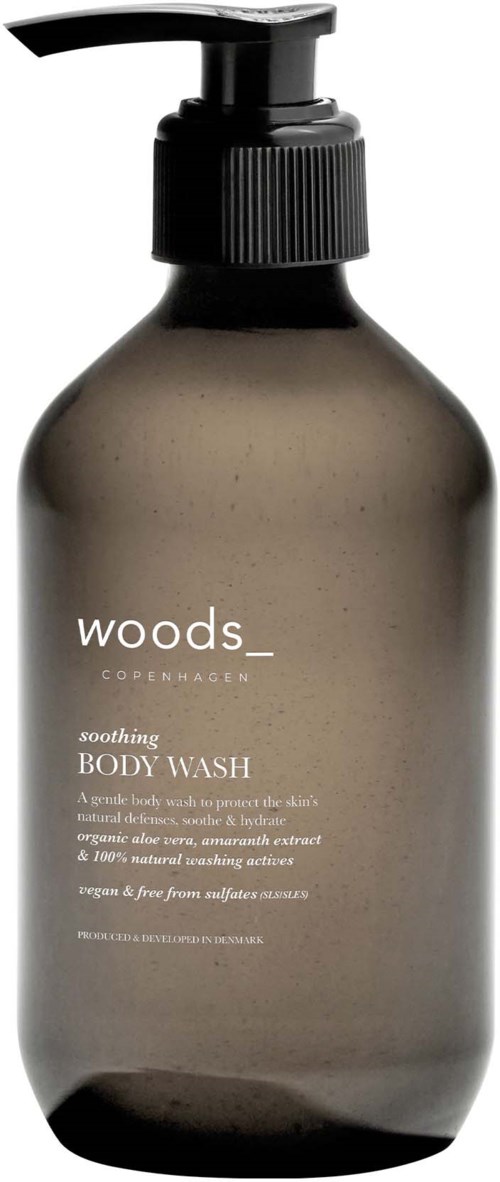 En brun flaske fra Woods Copenhagen med pumpe for kroppsvask og hvit tekst.