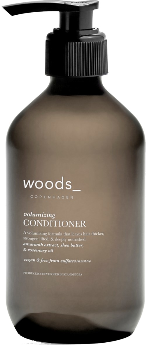 Eine braune Pumpflasche mit "woody" und "Copenhagen" beschriftet, enthält volumisierenden Conditioner mit schlichtem, minimalistischen Design.