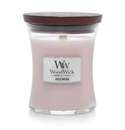 Keltainen tuoksukynttilä lasipullossa ruskealla kannella, merkinnällä 'WoodWick' ja 'Rosewood.'