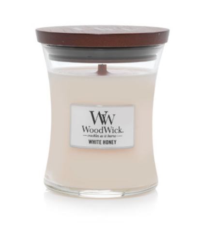 A white candle in a glass jar with a brown lid, labeled 'WoodWick White Honey'.