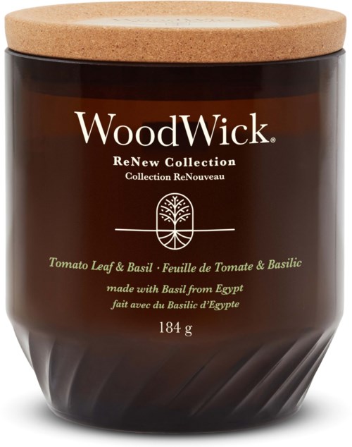 Een bruin kaarshouder met kurken deksel, gelabeld 'WoodWick' en met 'Tomato Leaf & Basil,' gemaakt met basilicum uit Egypte.