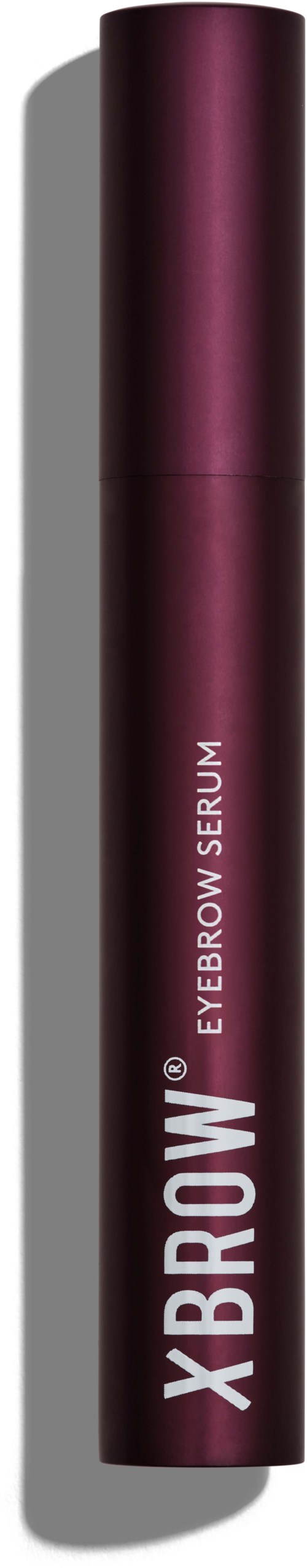 Donkerpaarse cilindervormige container met 'X BROWE Eyebrow Serum' erop, tegen een zwarte achtergrond.
