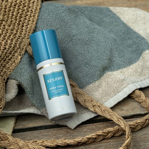 Spray deodorant w kulce na ręczniku, z lina w pobliżu, w rustykalnym otoczeniu.