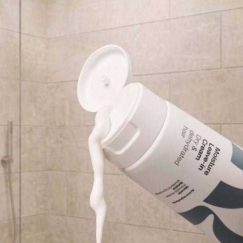 White bottle of Neutrogena Chinese Leav on the bathroom wall with lotion coming out of the open cap.