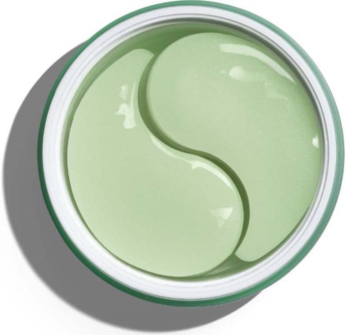 Ein runder grüner Behälter mit einem Yin-Yang-Symbol darin, auf einer schattigen Oberfläche.