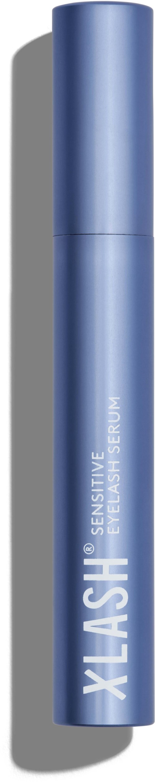 Een blauwe cilindervormige container, waarschijnlijk een cosmetisch of huidverzorgingsproduct, met het label 'Xlash' en 'Sensitive Eye Serum'.