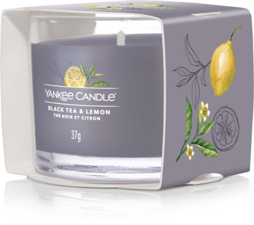 Ett doftljus med etikett 'Yankee Candle Black Tea & Lemon,' med citron, citronblad och blommor på förpackningen.