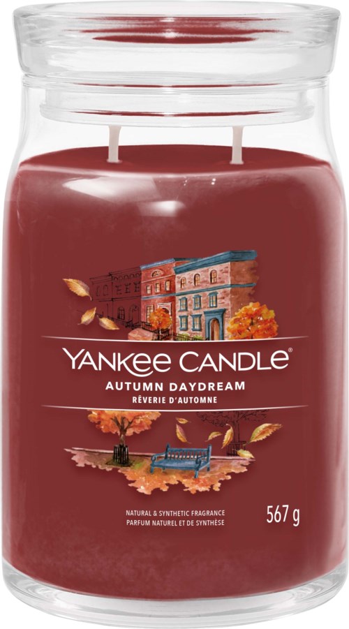Grote pot Yankee Candle herfstgeur met afbeeldingen van gebouwen en bladeren op het etiket.