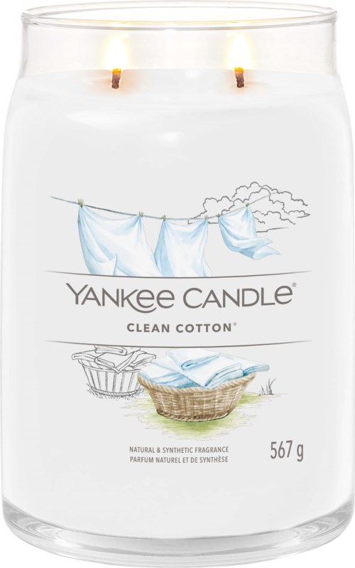 En vit doftljus med två vaxhöljen, märkt Yankee Candle Clean Cotton, med torkdukar och tvätt på dess etikett.