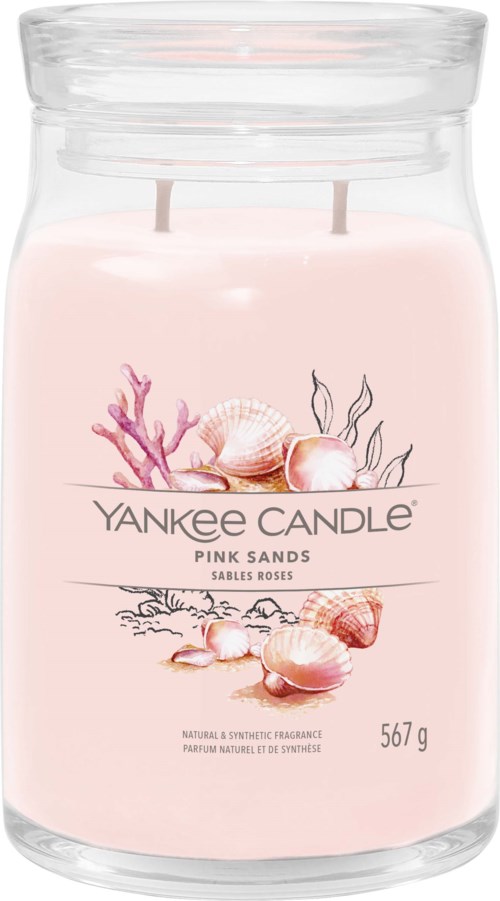 Różowa świeca zapachowa w szklanym słoiku z ilustracjami koralowców i muszli, oznaczona 'Yankee Candle Pink Sands'.