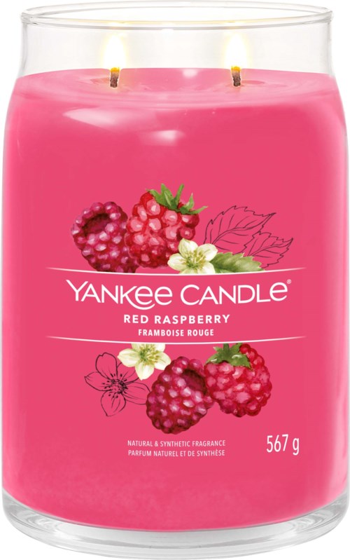 A pink Yankee Candle with two lit wicks, decorated with raspberries, flowers, and leaves, scent is red raspberry.