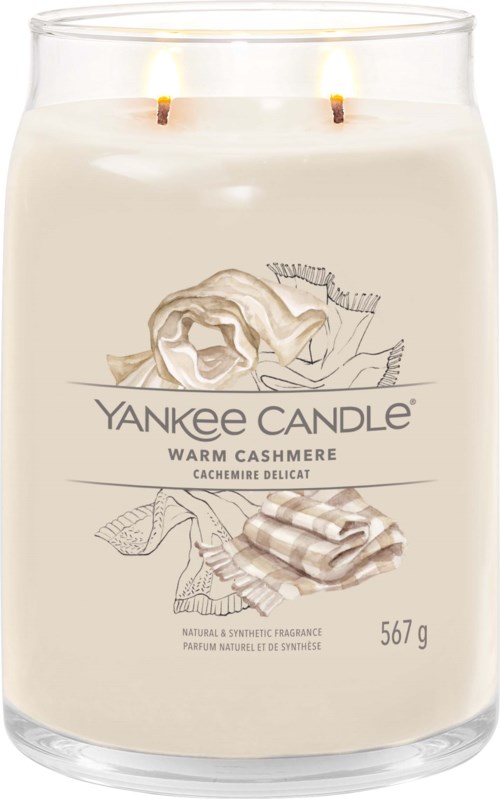 Eine große Duftkerze mit zwei Flammen, labeled Yankee Candle Warm Cashmere, riecht nach Kaschmir mit Bild von Kaschmirstoff und Blume.