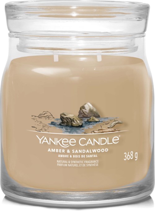 Crèmekleurige kaars in glazen pot, gemarkeerd 'Yankee Candle Amber & Sandalwood', weegt 368 gram.