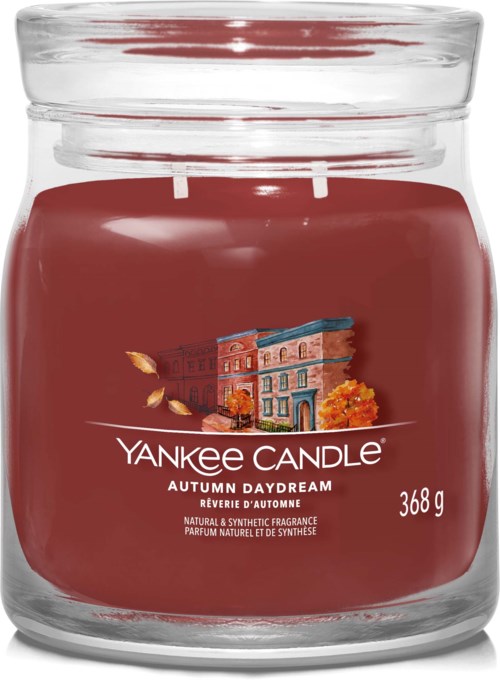 A red Yankee Candle jar labeled 'Autumn Daydream' with a picture of a building and fall leaves.