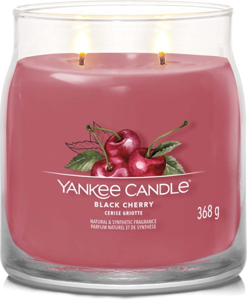 Roze geurkaars met kersen en groene bladeren, label zegt Yankee Candle Black Cherry, 368g, heeft twee vlammen.