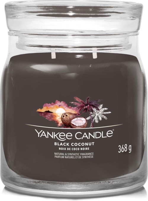 Een zwarte geurkaars in een glazen pot met deksel. Het label zegt "Yankee Candle Black Coconut" en toont een kokosnoot, zonsondergang en palmboom.