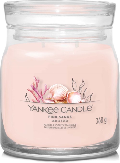En liten rosa doftljus med snäckor och koraller inuti i en klar glasburk.