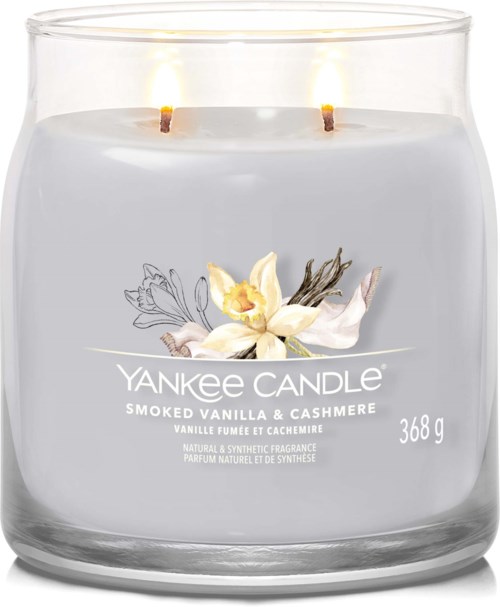 A white candle in a glass jar with two flames, labeled as Yankee Candle Smoked Vanilla & Cashmere, weighing 368 grams.