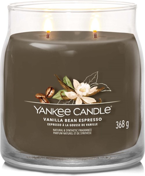 A dark-colored Yankee Candle with white flowers and coffee beans on the label, two lit wicks, and 368g weight.