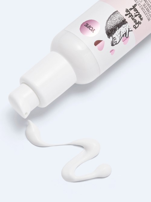 Eine weiße Flasche mit rosa Etikett und einem cartoonartigen Hund, aus der Creme tropft.