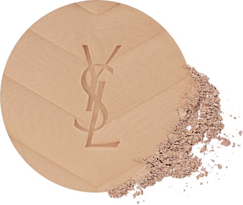 A round beige makeup product with Yves Saint Laurent logo, with powder spilled on one side.
