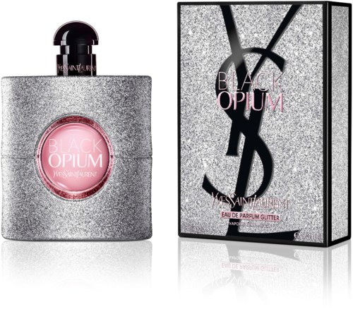 Eine glitzernde silberne Parfümflasche mit rosa Etikett und schwarzem Deckel neben einer passenden silbernen Verpackung mit Yves Saint Laurent-Logo.