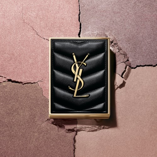 Eine schwarze Lederbrieftasche mit goldener Logo, auf zerbrochenem rosa-braunem Untergrund.